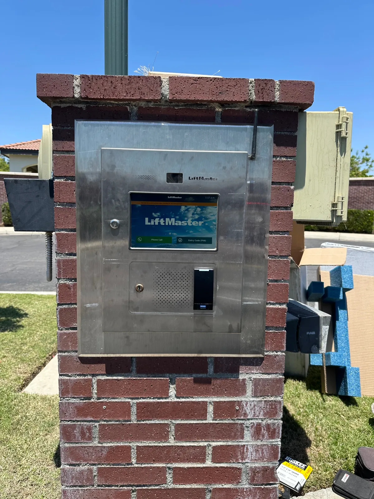Brick utility box with a metal access panel and meter in a grassy outdoor Bakersfield area